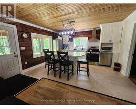A kitchen with a dining table and chairs.