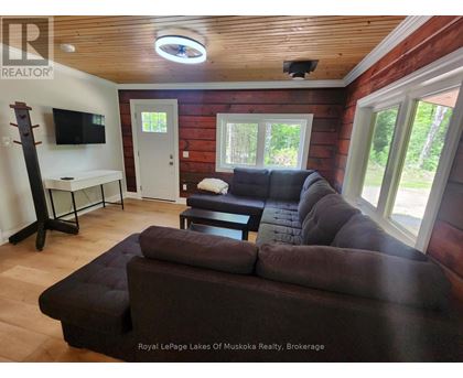 A living room with a brown couch and a wooden ceiling.