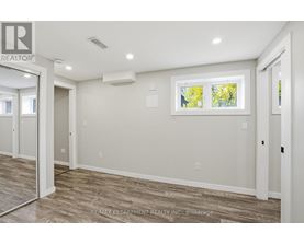 A room with a window showing trees outside.