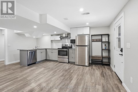 A kitchen with wooden floors and stainless steel appliances.