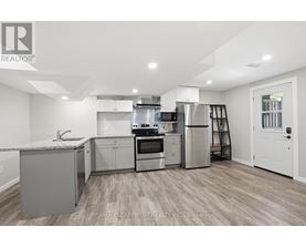 A modern kitchen with stainless steel appliances and wooden flooring.