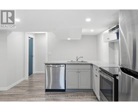 A modern kitchen with stainless steel appliances and white cabinets.