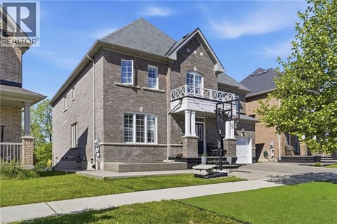 A house with a grey facade and a balcony with white railings.