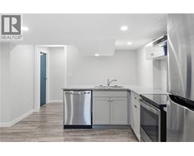 A modern kitchen with stainless steel appliances and a marble countertop.