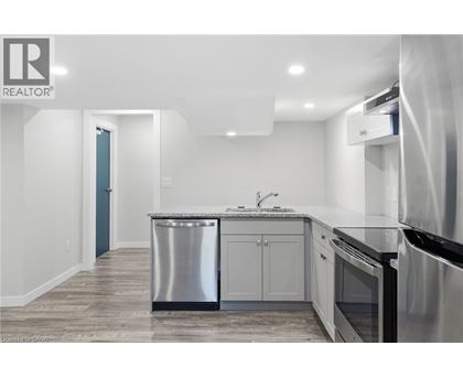 A modern kitchen with stainless steel appliances and a marble countertop.