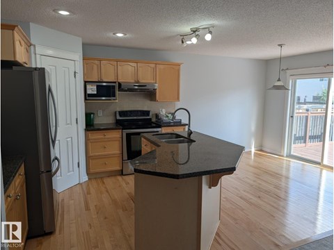 A kitchen with wooden cabinets and a black countertop.