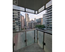A balcony overlooks a cityscape with buildings and a street below.