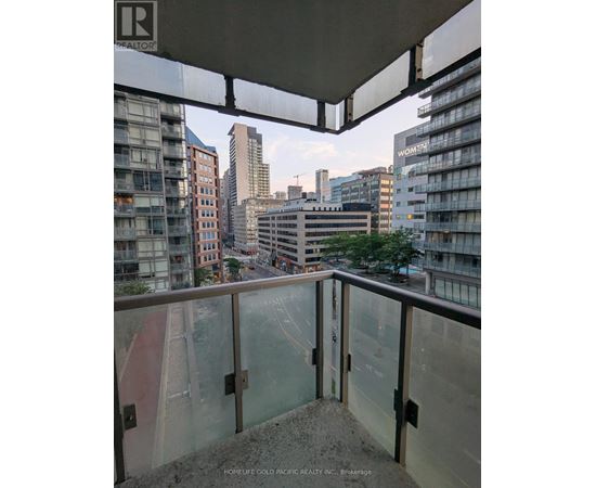 A balcony overlooks a cityscape with buildings and a street below.