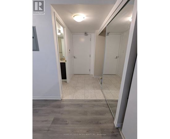 A hallway with white walls and a wooden floor.