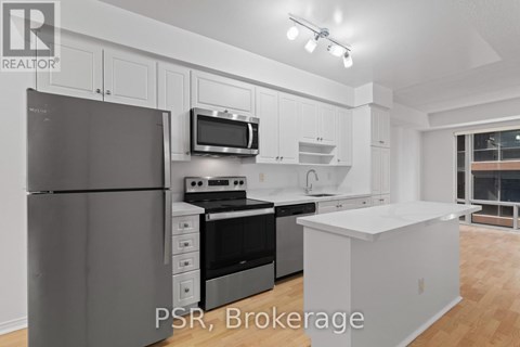 A modern kitchen with white cabinets and stainless steel appliances.