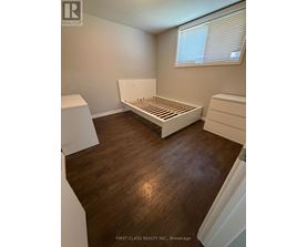 A bedroom with a bed, dresser and nightstand.