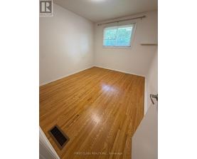 A room with wooden flooring and a window.