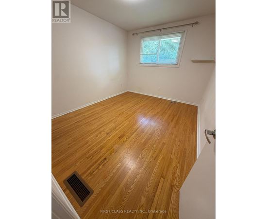 A room with wooden flooring and a window.