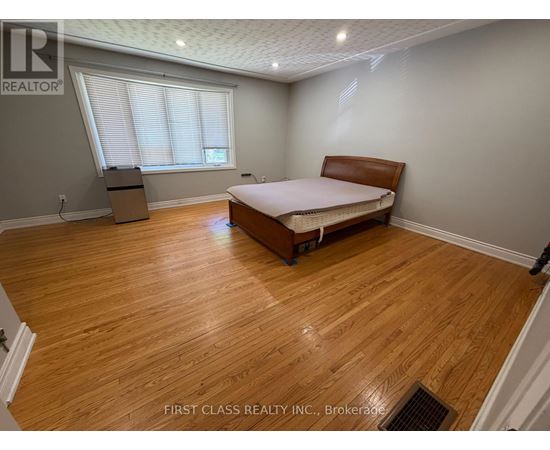 A bedroom with a bed, dresser, and window.