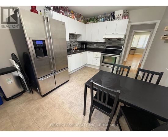 A kitchen with a black table and chairs.