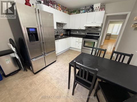 A kitchen with a black table and chairs.