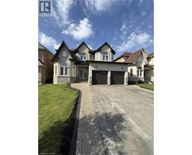 A large, well-maintained house with a driveway in front.