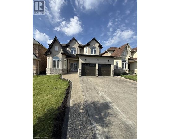 A large, well-maintained house with a driveway in front.
