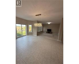 A spacious living room with a chandelier and sliding glass doors.