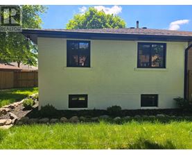 A small white house with a black roof and two windows.
