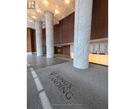 A carpet with the words "King's Landing" on it is in the foreground of a room with pillars and wooden walls.