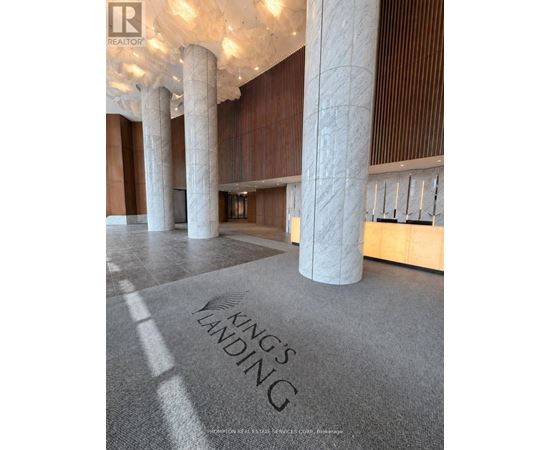 A carpet with the words "King's Landing" on it is in the foreground of a room with pillars and wooden walls.