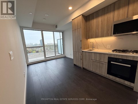 A kitchen with wooden cabinets and a black oven.