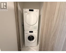 A white washer and dryer stacked on top of each other in a small space.
