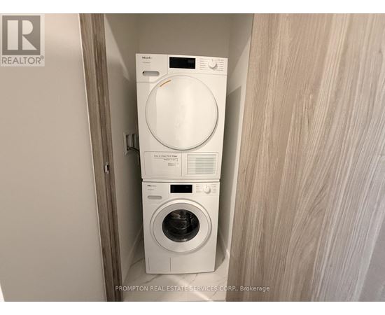 A white washer and dryer stacked on top of each other in a small space.