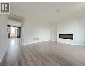 A spacious room with wood flooring and a fireplace.