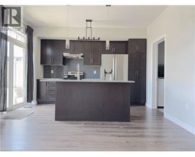 A modern kitchen with dark brown cabinets and a large island.