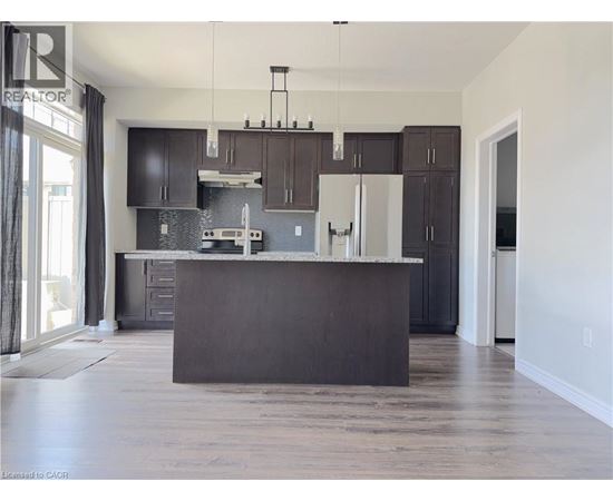 A modern kitchen with dark brown cabinets and a large island.