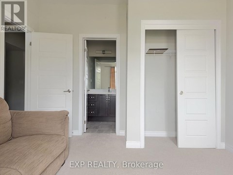 A living room with a couch and a doorway leading to a kitchen.