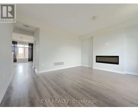 A spacious room with wood flooring and a fireplace.