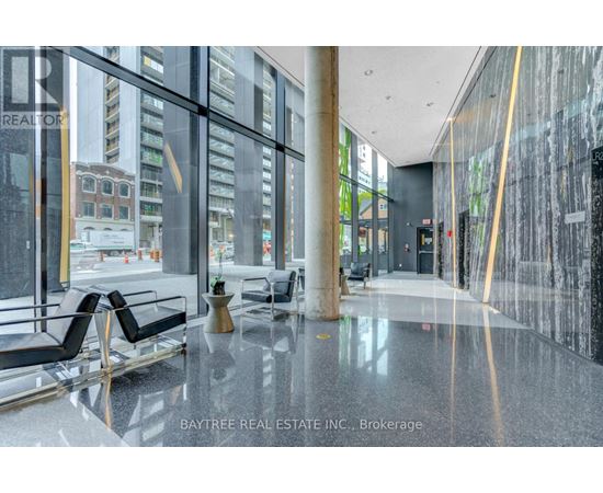 A Baytree Real Estate Inc. brokerage office with a glass wall and black chairs.