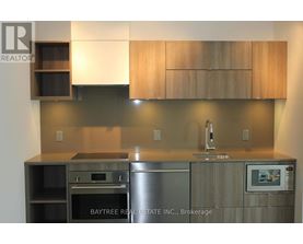 A modern kitchen with wooden cabinets and stainless steel appliances.