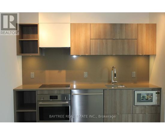 A modern kitchen with wooden cabinets and stainless steel appliances.