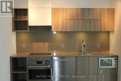 A modern kitchen with wooden cabinets and stainless steel appliances.