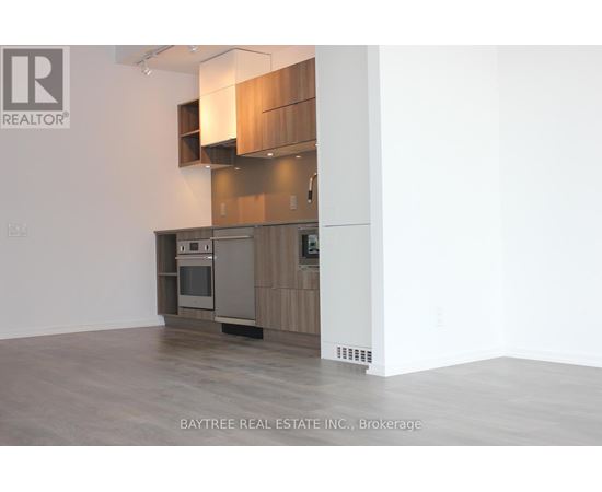 A modern kitchen with wooden cabinets and a stainless steel oven.