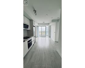 A spacious kitchen with a microwave above the stove and a view of the backyard through the open door.