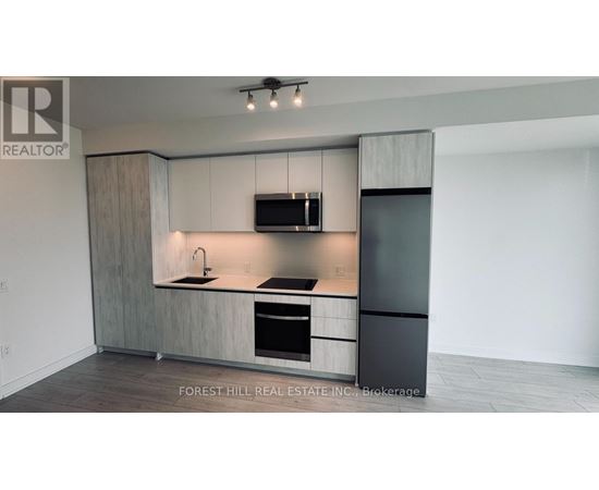 A modern kitchen with a sink, stove, and refrigerator.