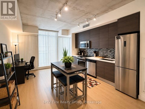 A modern kitchen with a dining table and chairs.