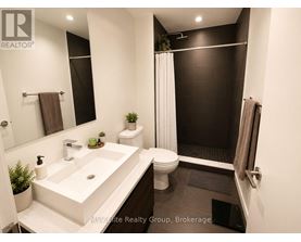 A bathroom with a white sink and black tiles.