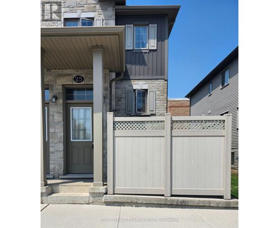 A grey house with a white fence in front.