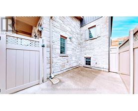 A white gate is closed on a stone wall.