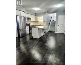 A kitchen with a refrigerator, stove, and bar stools.