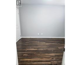 A room with a wooden floor and a white door.