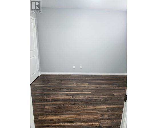 A room with a wooden floor and a white door.