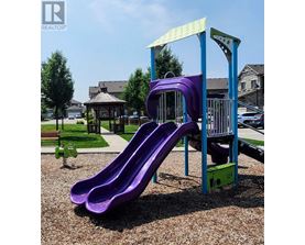 A purple slide in a playground with a blue and green structure.