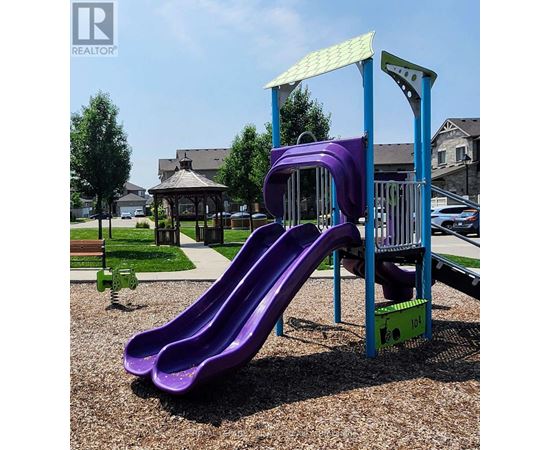 A purple slide in a playground with a blue and green structure.